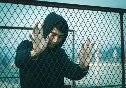 A sad man behind fence stock photo