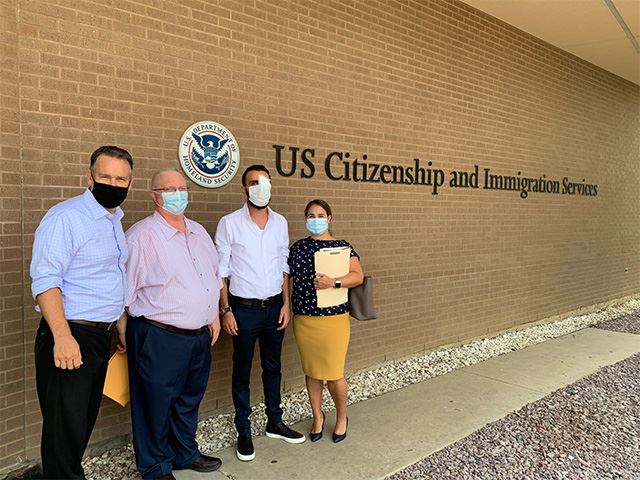 Photo with client in front of USCIS with face masks.